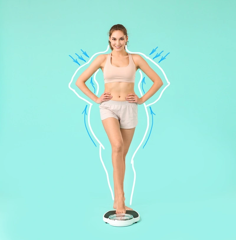 Happy woman standing on weight machine | Mesa Medical Health & Wellness | St. George, UT